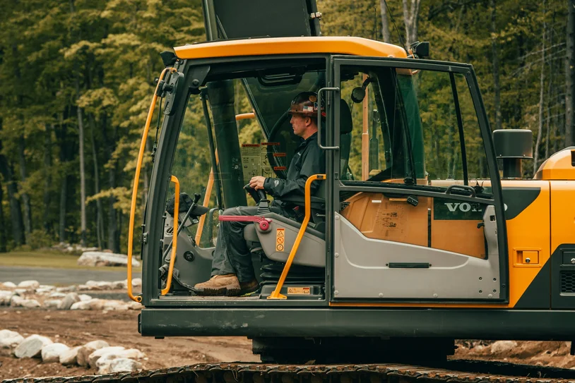 Operator working inside the cab of an excavator on a construction site