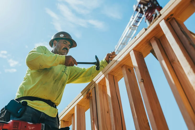 Contractor hammering wood framing on a residential construction site