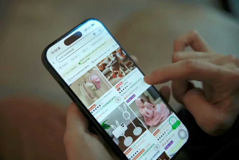 Close-up of a hand scrolling a product catalog on a smartphone