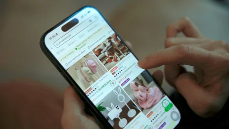 Close-up of a hand scrolling a product catalog on a smartphone
