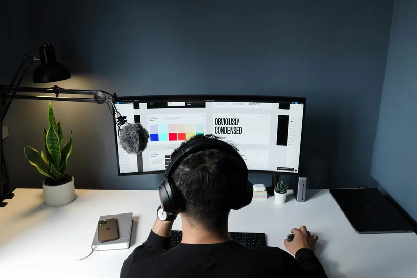 Person wearing headphones working at a minimalist home office desk