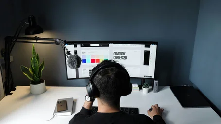 Person wearing headphones working at a minimalist home office desk