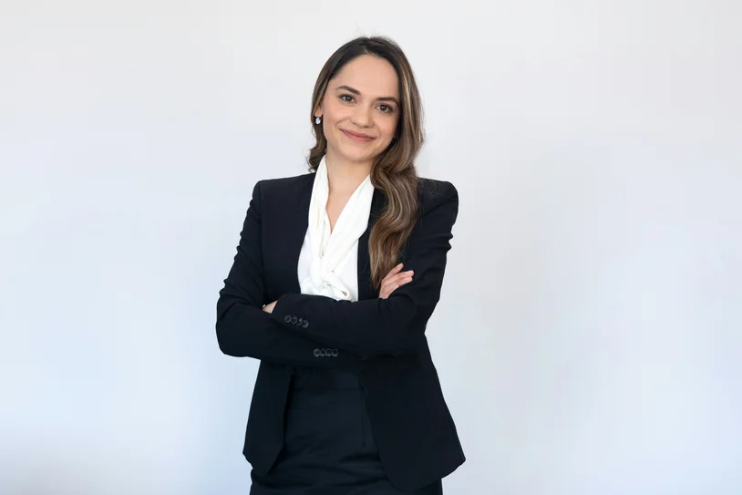 Confident female attorney in a black blazer standing with arms crossed