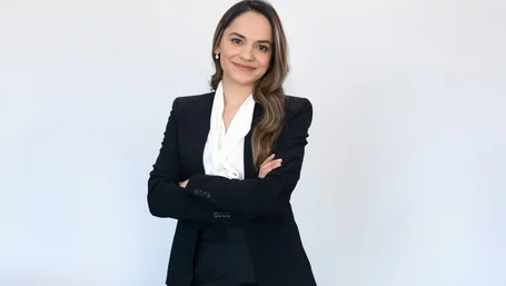 Confident female attorney in a black blazer standing with arms crossed