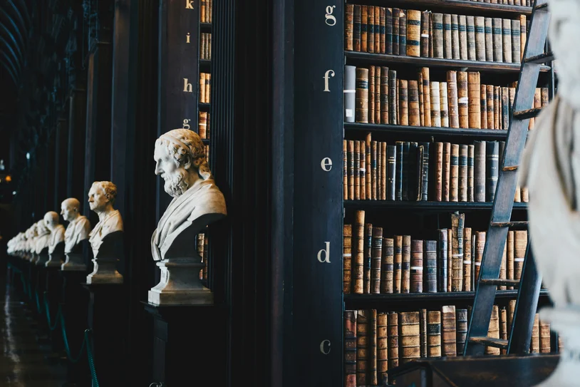 Row of classical marble busts beside an ornate antique law library bookshelf