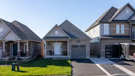 Row of suburban houses with driveways on a sunny residential street