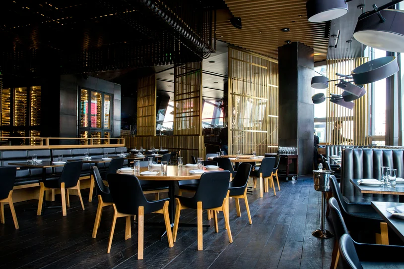 Upscale restaurant dining room with set tables and pendant lighting