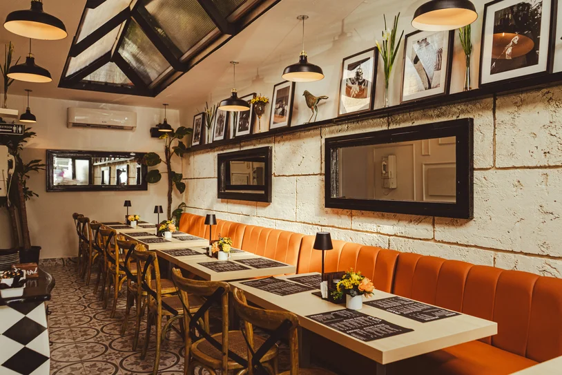 Cozy restaurant dining area with orange booths and menus set on each table