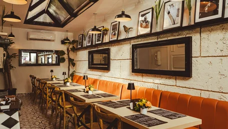 Cozy restaurant dining area with orange booths and menus set on each table