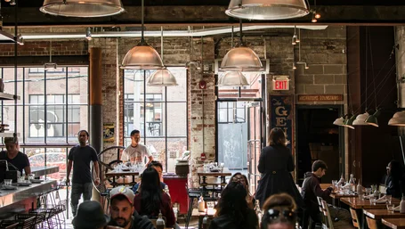 Crowded industrial-style restaurant full of diners and staff