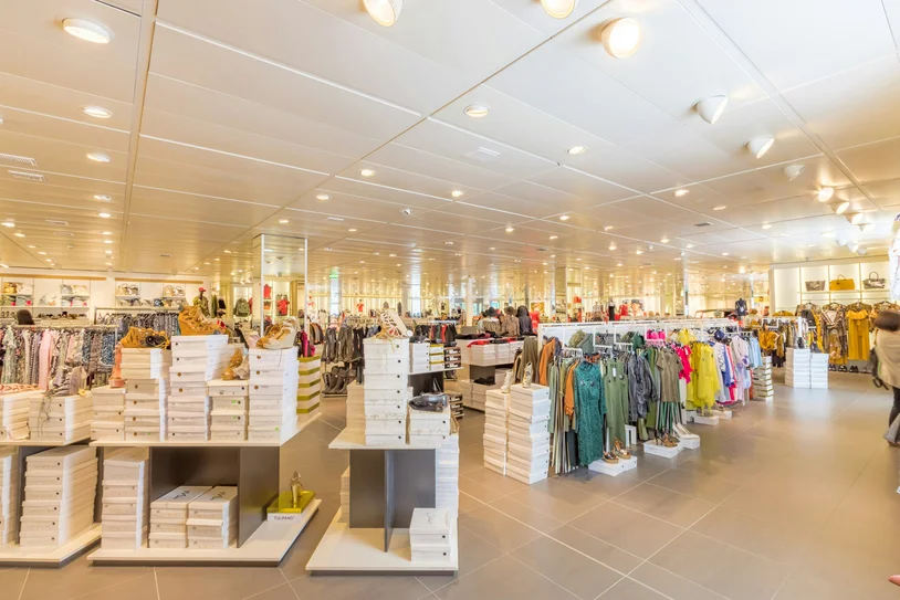 Organized retail store shelves stocked with shoes and folded clothing