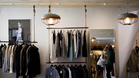 Customer browsing clothing racks inside a small independent boutique
