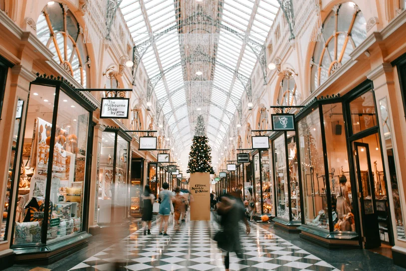 Shoppers walking through an elegant historic shopping arcade decorated for the holidays