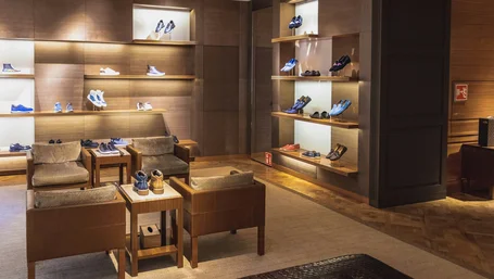 Curated shoe display on lit wooden shelves in an upscale boutique